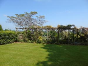 una recinzione di legno in un cortile con prato di Bond's Cottage Barn a Royal Tunbridge Wells