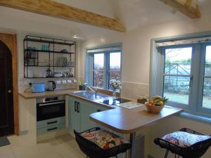 una cucina con lavandino e bancone con due sgabelli da bar di Bond's Cottage Barn a Royal Tunbridge Wells