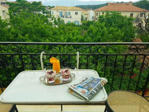 una mesa en un balcón con un libro y dos tazas en Hotel Galaxidi, en Galaxidhion