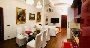 a living room with white chairs and a glass table at Colosseo Room in Rome