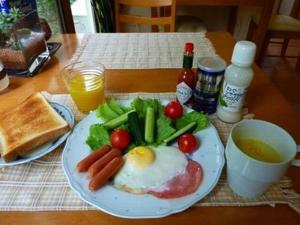 un plato de comida con huevos y verduras en una mesa en Guesthouse Mintaro Hut, en Yamagata