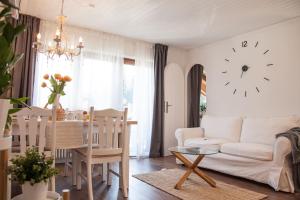 sala de estar con sofá blanco y reloj en la pared en Apartment JoniFee am Titisee, en Titisee-Neustadt