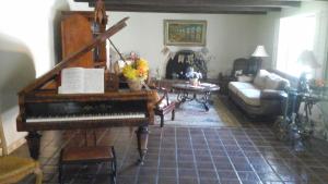 sala de estar con piano y sofá en Spanish Villa Inn, en St. Helena