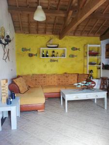 a living room with a couch and tables at Fisherman's House Azores in Angra do Heroísmo