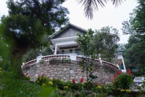 dom za kamienną ścianą z kwiatami w obiekcie Chithirapuram Palace w mieście Munnar