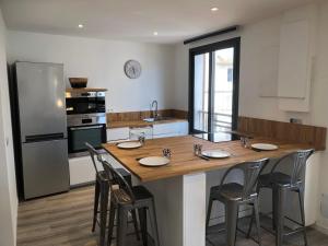 een keuken met een grote houten tafel en stoelen bij Appartement port bonifacio in Bonifacio