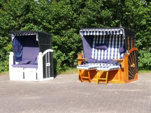 Hay dos sillas de mimbre en un patio. en Mare Balticum Urlaub auf Rügen, en Sagard