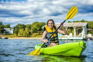 une femme assise dans un kayak sur l'eau dans l'établissement Still Waters Resort, à Branson