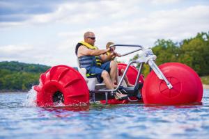 un homme assis sur un bateau dans l'eau dans l'établissement Still Waters Resort, à Branson