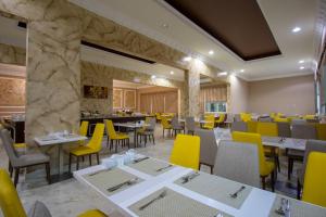 un restaurante con mesas, sillas y sillas amarillas en Flamingo Beach Hotel, en Umm Al Quwain