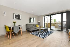 uma sala de estar com um sofá e uma mesa em Esquire Apartments Ealing em Londres