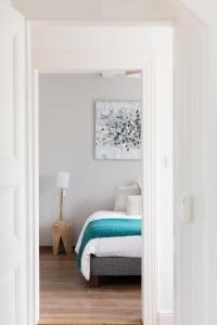 um quarto com uma cama num quarto branco em Reflets Sur La Lauch appartements em Colmar