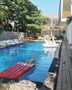 einen Swimmingpool mit Schwan und Schwan in der Unterkunft Deja Vu in Gili Trawangan