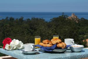 - une table avec petit-déjeuner composé de croissants et de jus d'orange dans l'établissement Capo D'orto - Porto - Corse, à Porto Ota