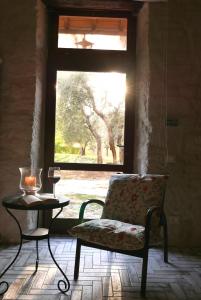 Habitación con silla y mesa con ventana en Agriturismo La Pieve, en Colle Val D'Elsa