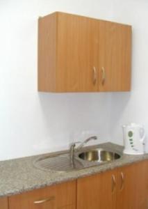 a kitchen counter with a sink and wooden cabinets at MOSiR Reda in Reda