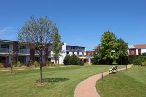 einem Park mit einer Bank vor einem Gebäude in der Unterkunft SEETELHOTEL Nautic Usedom Hotel & Spa in Ostseebad Koserow