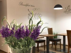 un vase rempli de fleurs violettes sur une table dans l'établissement Hotel Bonus, à Kolomya