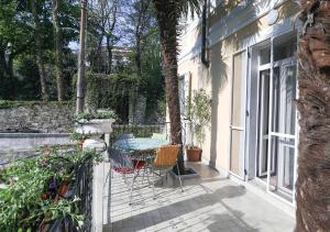 une terrasse avec une table et des chaises dans une maison dans l'établissement Le Palme Trieste, à Trieste