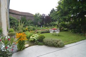 un giardino con tavolo, sedie e fiori di Chambre d'hôtes à TOUL centre ville avec parking privé a Toul