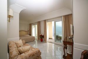 a living room with a couch and a bed and a window at Hotel Villa Fraulo in Ravello