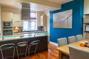 una cocina con mesa de comedor y una pintura de puente en la pared en Apartment No 1 - The Old Red King Pub, Whitefield, Manchester, en Mánchester