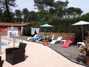 patio z leżakami i parasolami przy basenie w obiekcie Apparthotel proche de Cannes w mieście Mouans-Sartoux