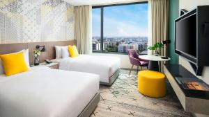 pokój hotelowy z 2 łóżkami i dużym oknem w obiekcie Avani Sukhumvit Bangkok Hotel w mieście Bangkok