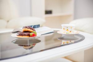 - une table avec deux assiettes de desserts et une tasse de café dans l'établissement Willa Laguna, à Kołobrzeg