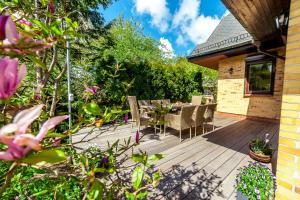 une terrasse en bois avec une table et des chaises. dans l'établissement Willa Laguna, à Kołobrzeg