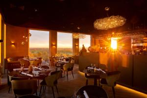 ein Restaurant mit Tischen und Stühlen und Aussicht in der Unterkunft Dormio Hotel De Prins van Oranje in Maastricht