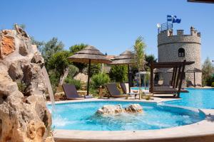 uma piscina com uma fonte de água em frente a um castelo em Villa Elia Resort em Lefkada Town