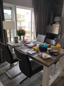 een houten tafel met eten in de woonkamer bij Chalet SOL Y MAR in Renesse