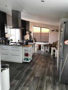 een keuken met witte apparatuur en houten vloeren bij Chalet SOL Y MAR in Renesse