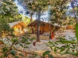 ein Haus im Wald mit Bäumen in der Unterkunft Camping Maremma Sans Souci in Castiglione della Pescaia