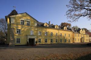 een groot geel gebouw met veel ramen bij Pałac Lucja BB in Zakrzów