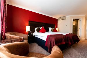 ein Hotelzimmer mit einem Bett mit einer roten Wand in der Unterkunft Rose And Crown Hotel in London