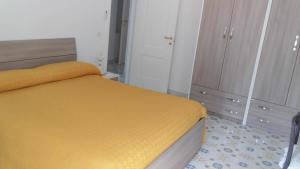 1 dormitorio con cama amarilla y armario en Holidays Baia D'Amalfi, en Amalfi