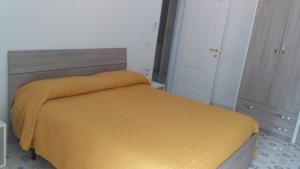 Un dormitorio con una cama con una manta amarilla. en Holidays Baia D'Amalfi, en Amalfi