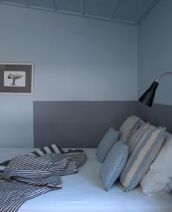 a white bed with pillows and a lamp on it at Sto Roloi Island Houses in Poros