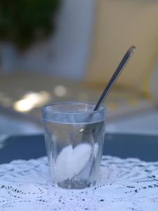 a plastic cup with a spoon in it on a table at Sto Roloi Island Houses in Poros