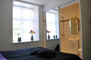 1 dormitorio con 1 cama, lavamanos y 2 ventanas en AB Centrum Aarhus Bed without Breakfast, en Aarhus