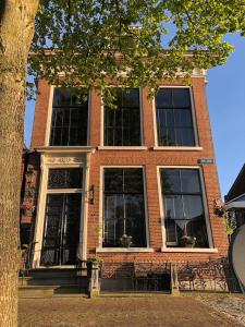 a brick building with black doors and windows at B&B Diepzicht in Dokkum