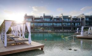 um edifício com cadeiras numa doca na água em Quellenhof Luxury Resort Lazise em Lazise