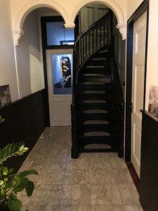 a hallway with a spiral staircase in a house at B&B Diepzicht in Dokkum