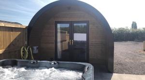 - un petit bâtiment avec une baignoire dans la neige dans l'établissement Superior Glamping Pod with Hot Tub, à Frodsham