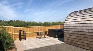 d'une terrasse avec un grill, une table et des chaises. dans l'établissement Superior Glamping Pod with Hot Tub, à Frodsham