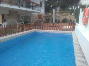 een groot blauw zwembad naast een gebouw bij VILLA GARDEN in Tarragona