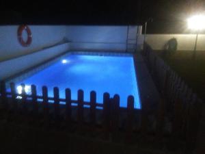 een zwembad 's nachts met een licht erin bij VILLA GARDEN in Tarragona