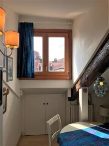 - une chambre avec une fenêtre, un lit et une table dans l'établissement Casa Tella, à Venise